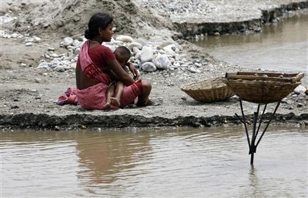 A women in India with her child on the banks of the river Balason on Mother's Day on the outskirts of the city of Siliguri.