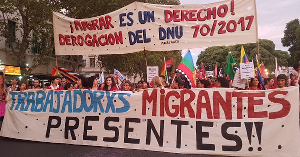 Migrant rights activists hold banners saying 
