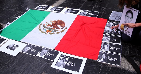 Photos of murdered journalists border the Mexican flag in a protest against the 106 reporters who fell victim to the mass killings in Mexico since 2000.