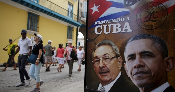 Tourists walk past images of Cuban President Raul Castro and his former U.S. counterpart Barack Obama in Havana, March 17, 2016.