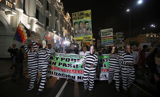 Protesters dressed in mock prison outfits and wearing face masks of Peru's President Pedro Pablo Kuczynski and fellow politicians.