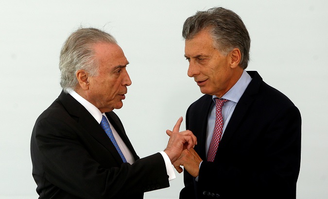Brazil's President Michel Temer (L) talks with his Argentinian counterpart Mauricio Macri before they pose for a family photo at Mercosur trade bloc annual summit in Brasilia, Brazil December 21, 2017.