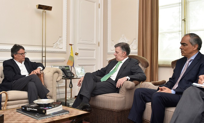 Colombia's President Juan Manuel Santos (C) at a meeting with peace commissioner Rodrigo Rivera (R), and chief peace negotiator Gustavo Bell (L).