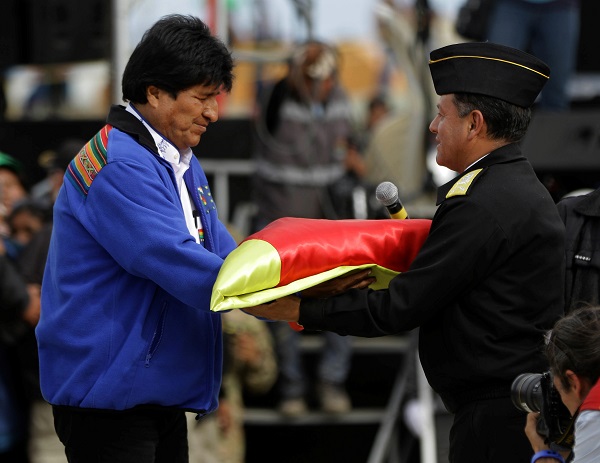 President Evo Morales hands a flag to Navy Commander Real Admiral Javier Ayllon during maritime flag day March 10.