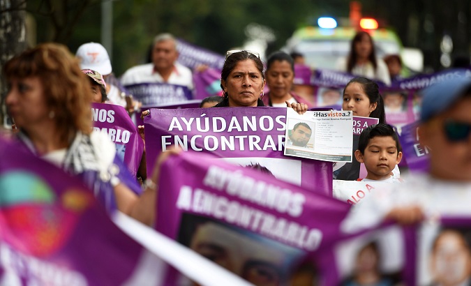 A woman holds banners with pictures of missing persons during a march to mark Women's Day in Xalapa, in the state of Veracruz, Mexico May 10, 2018.