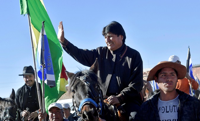 Bolivia's President Evo Morales waves while riding a horse as he arrives at Padcoyo, Chuquisaca, Bolivia, Aug. 23, 2018.