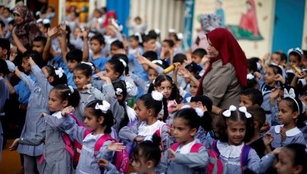 Palestinian schoolchildren participate in the morning exercise at an UNRWA-run school, on the first day of a new school year, in Gaza City.