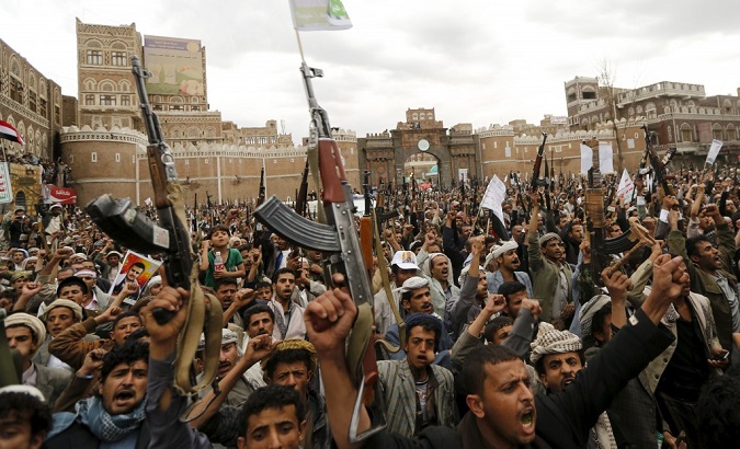 Rebels hold up their weapons during a rally against air strikes in Sanaa, Yemen, March 26, 2015.