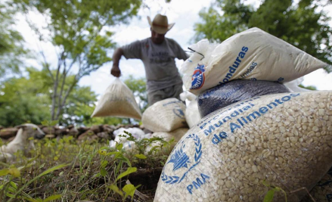 A farmer moves bags of provisions, donated by the U.N. World Food Programme (WFP), during food aid distribution to families affected by a drought, Aug. 28, 2014.