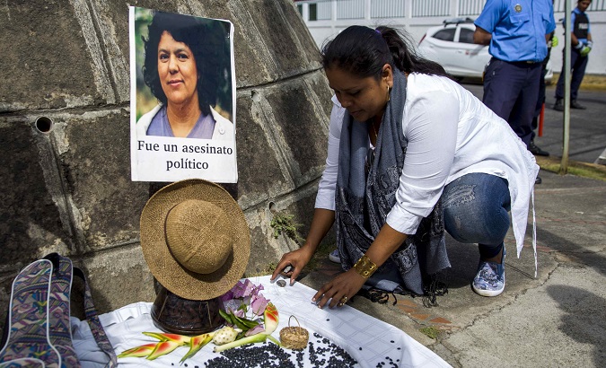 A woman places an offering in memoriam of Berta Caceres in one of the many international events honoring the environmental activist. Managua, Nicaragua. March 2, 2017.