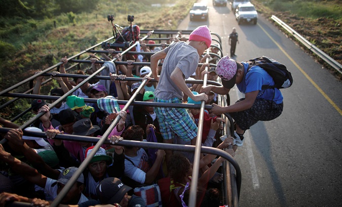 Migrants hitchhike on a truck along the highway to Arriaga from Pijijiapan, Mexico