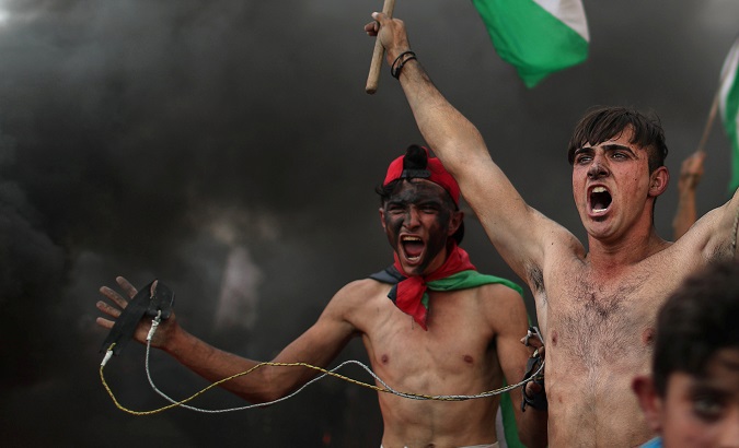 Palestinian demonstrators react during a protest at the Israel-Gaza border fence in Gaza.