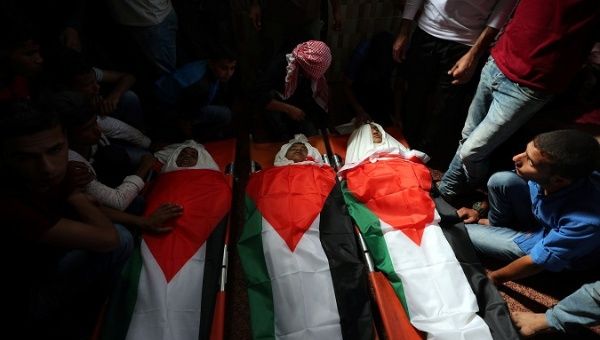 Mourners gather around the bodies of Palestinian boys who were killed in an Israeli air strike on the Gaza Strip frontier, during their funeral in the central Gaza Strip Oct. 29, 2018. 
