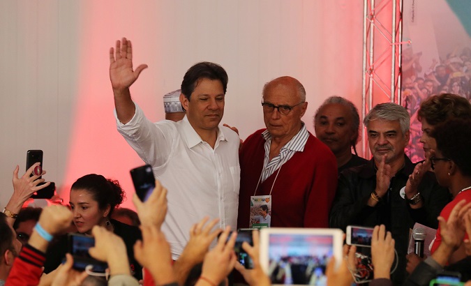 Fernando Haddad waves during a news conference during a runoff election in Sao Paulo, Brazil Oct. 28, 2018.