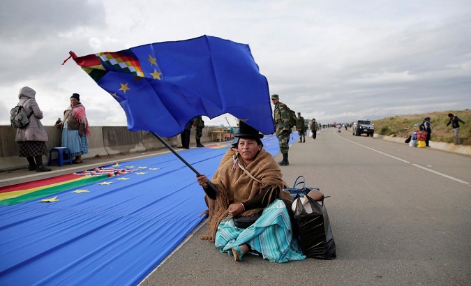 A woman holds a flag during the maritime flag day in la Apacheta, near El Alto, Bolivia March 10, 2018.