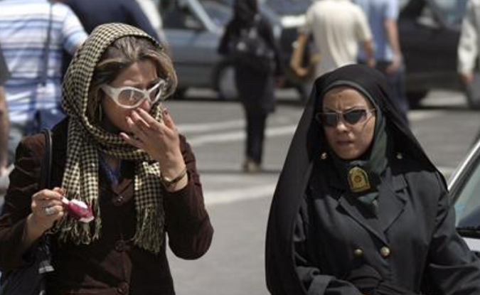 A policewoman (R) warns a woman about the state of her clothing and hair during a crackdown on adhering to the strict Islamic dress code in Tehran April 22, 2007.