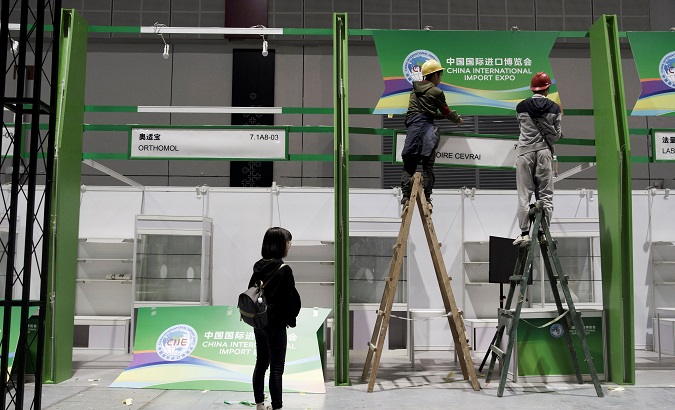 Workers put up a sign inside the National Exhibition and Convention Center, the venue for the upcoming China International Import Expo, in Shanghai, China, on October 28, 2018.