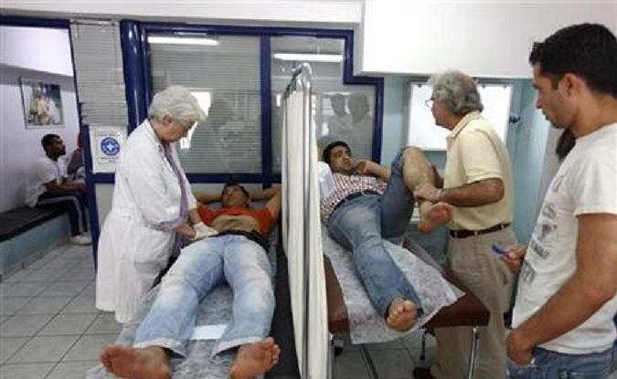 Doctors examine patients at a medical centre of the Greek delegation of the Doctors of the World in Athens May 31, 2012.