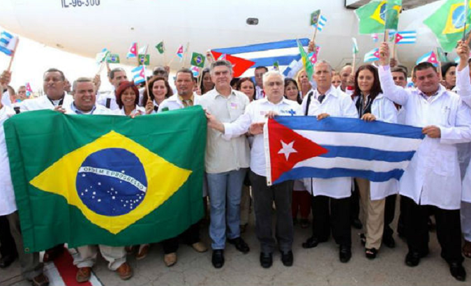Cuban doctors hold Brazilian and Cuban flags as they arrive in Brazil to be part of the 'Mais Medicos' program in the country.