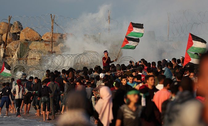A demonstrator holding Palestinian flags shouts during a protest calling for lifting the Israeli blockade on Gaza, at the beachfront border with Israel, in the northern Gaza Strip Nov. 5, 2018.
