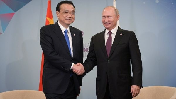 Russia's President Vladimir Putin (R) meets with China's Premier Li Keqiang at the East Asia Summit in Singapore on Nov. 15, 2018.