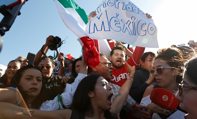 Anti-immigrant demonstrators hold signs reading 'Priority Mexico' as members of the migrant caravan arrive in Tijuana en route to the U.S. Tijuana, Mex Nov. 18, 2018.