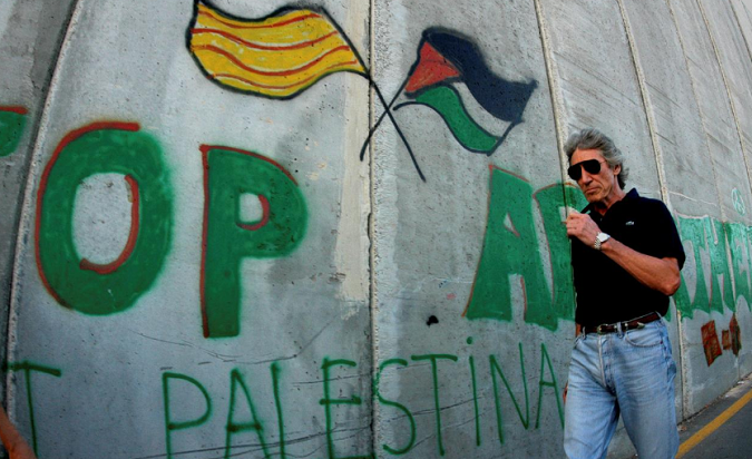 British rock star Roger Waters of Pink Floyd walks along the controversial Israeli barrier in the West Bank city of Bethlehem, June 21, 2006.