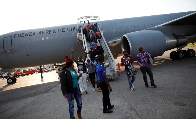 Haitians disembark from a Chilean Air Force plane in Haitii as part of the President Piñera's 'Humanitarian Return Plan' November 7, 2018