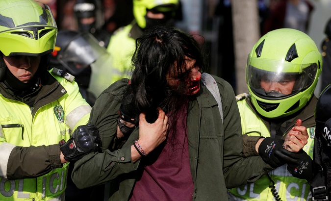Police hold a wounded man during a march of students in Bogota, Colombia, Nov. 15, 2018.