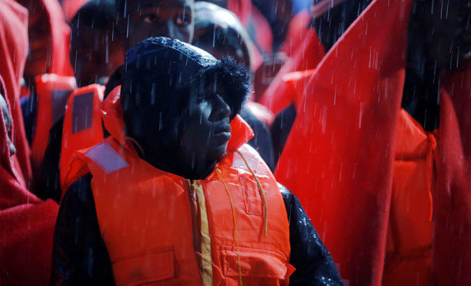 African refugees stand under the rain on a rescue boat at the port of Malaga, Spain Nov. 8, 2018.