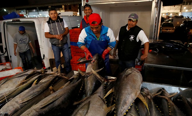 A worker checks the quality of Mexican tuna displayed at a fish market in Mexico City, Mexico, May 18, 2017.