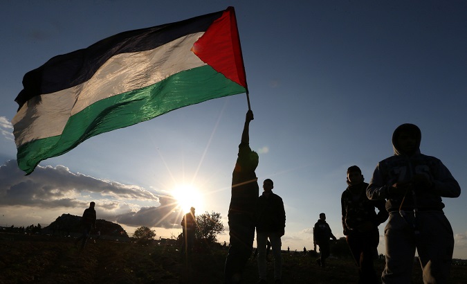 Demonstrator holds a Palestinian flag during a protests in the southern Gaza Strip, Dec. 21.