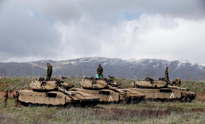 Israeli soldiers stand atop tanks in the Golan Heights near Israel's border with Syria March 19, 2014