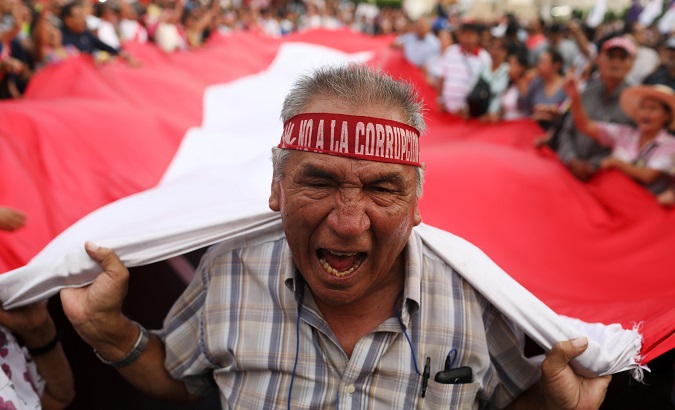 Protesters carry A Peruvian flag during anti-corruption protests in Lima.
