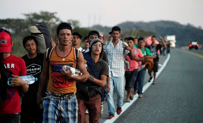 Migrants walk along a highway during their journey towards the United States, in Chauites, Mexico, Jan. 21, 2019.