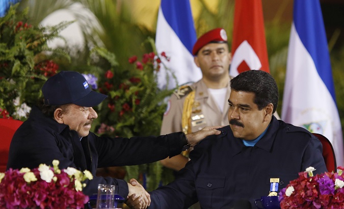 Venezuela's President Nicolas Maduro (R) and Nicaragua's President Daniel Ortega shake hands during a ceremony with Sandinista supporters in Managua.