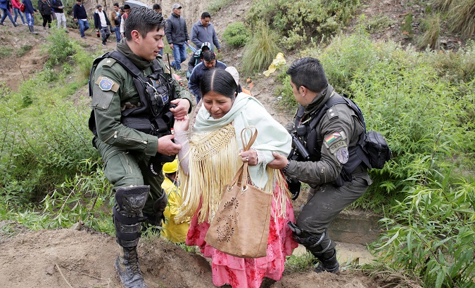 Police officers help a woman after a landslide caused by heavy rains in La Paz, Bolivia, Feb. 13, 2019.