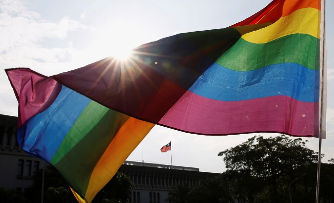 A rainbow flag is seen in front of Taiwan's flag during a rally to support the upcoming same-sex marriage referendum, in Taipei, Taiwan November 18, 2018.