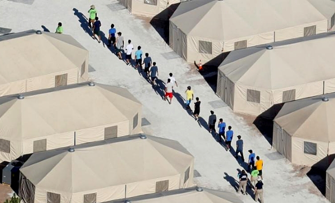 Immigrant children are shown walking in single file at the facility near the Mexican border in Tornillo.
