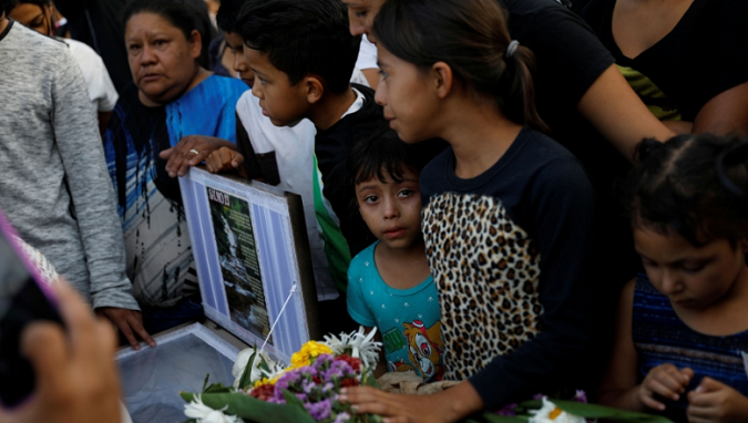 People stand next to the coffin of Saylin, 14, killed by gang members in Tegucigalpa, Honduras in July.