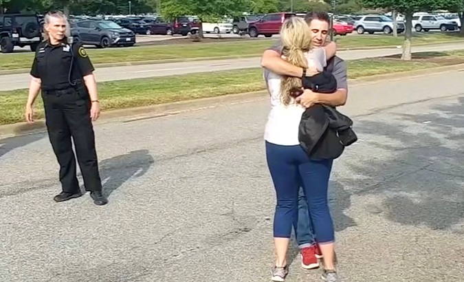 People embrace after being evacuated by police in this still image taken from video following a shooting at the municipal center in Virginia Beach, U.S. May 31, 2019.