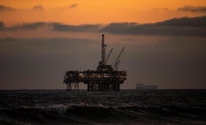 An oil rig sits off the shore at sunset in Huntington Beach, California, U.S., May 15, 2020.
