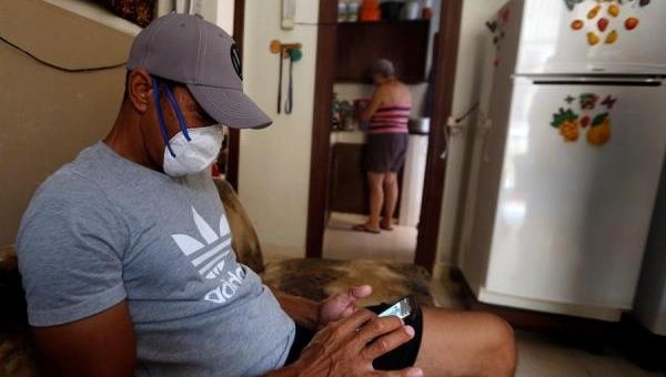 Cuban man checks his phone at home in quarantine due to the Covid-19 pandemic. April 7, 2020. Havana, Cuba.