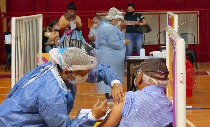 A nurse vaccinates an elderly man, Argentina, March. 25, 2021.