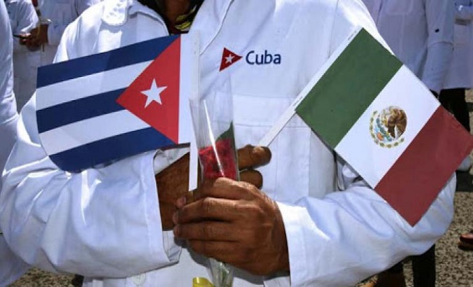 A doctor holds a Cuban flag and a Mexican one, June, 2021.