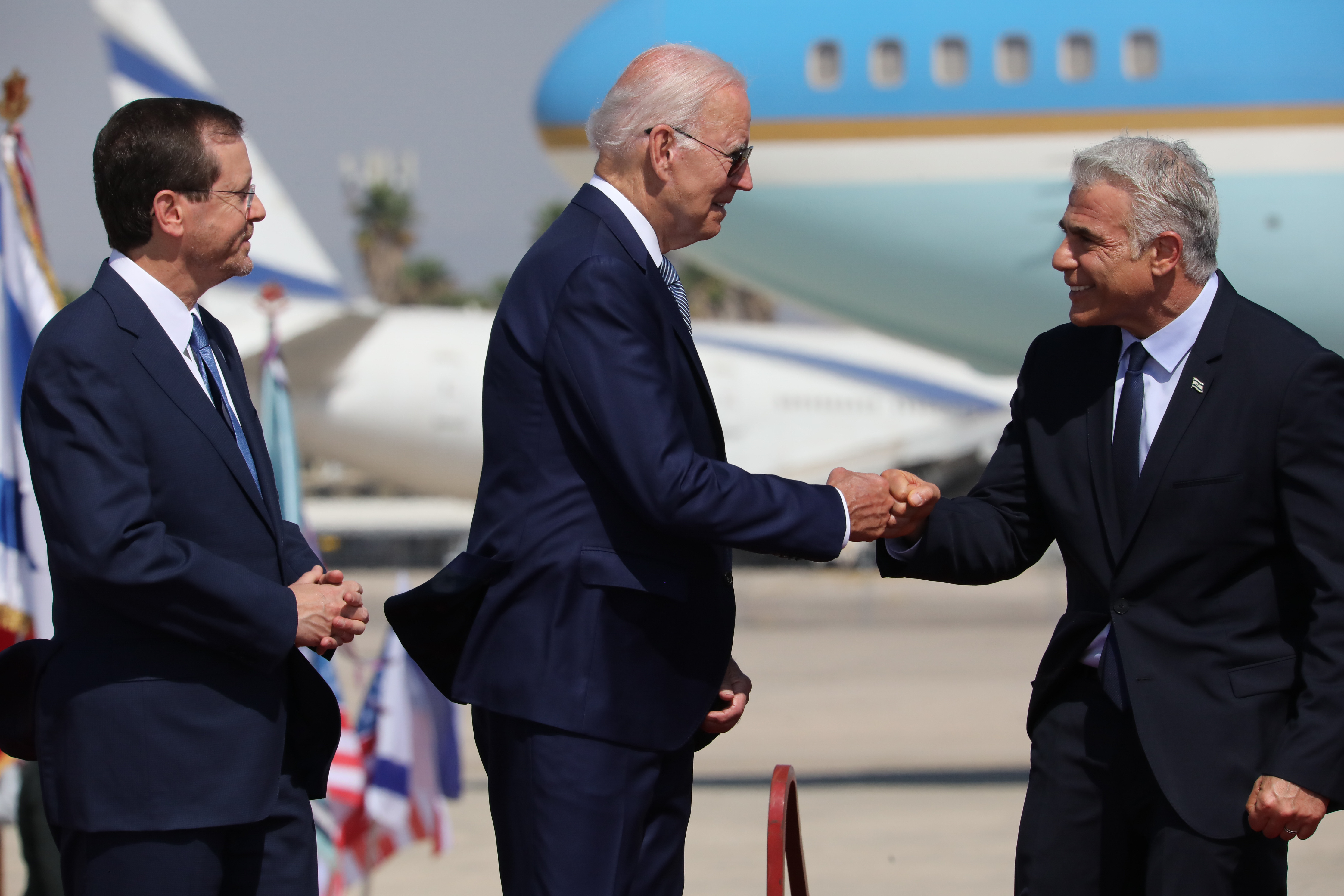 Israeli President Issac Herzog (L) and Prime Minister Yair Lapid (R) welcome U.S. President Joe Biden at Ben Gurion Airport in Tel Aviv, Israel, July 13, 2022.