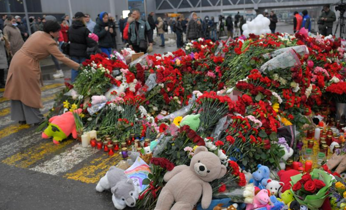 People lay flowers to mourn victims of a terrorist attack in Moscow, Russia, March 24, 2024.