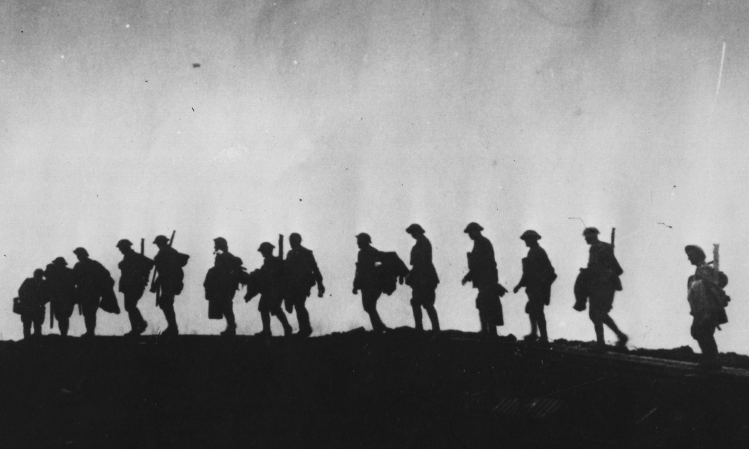 A plattoon of british soldiers walking out of the trenches.