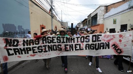 Resistance group Movimiento Unificado Campesino del Aguan (Unified Campesino Movement of the Aguan) holds a sign that says “No more murders of campesinos in the Aguan.” (Photo: AFP)