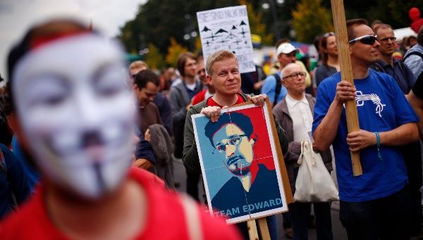 A man holds a placard with a portrait of former U.S. National Security Agency contractor Edward Snowden.